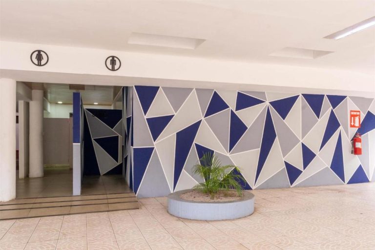 Entrada a los baños con decoración geométrica azul y gris del Best Western Las Mercedes Airport