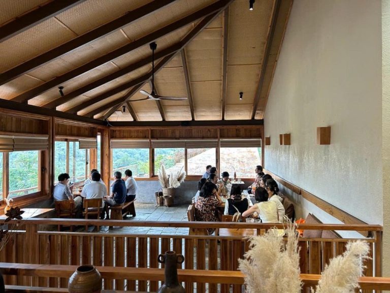 Restaurante con terraza panorámica y techo de madera en MăngDiang Boutique Hotel con vistas al bosque