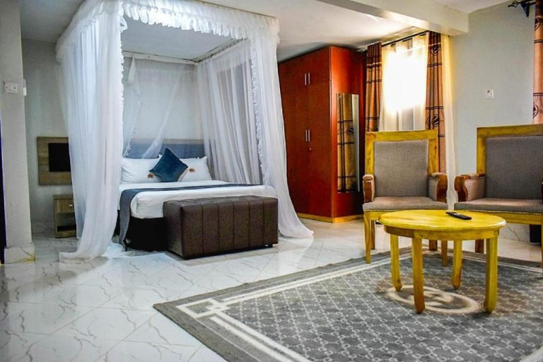 Suite con cama de dosel y sala de estar elegante en Elboran Resort and Spa