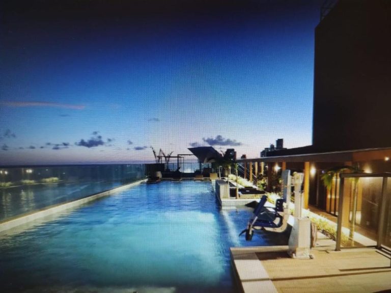 Piscina infinita en terraza del Studio Luxuoso frente Mar con vistas al océano al atardecer