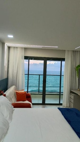 Habitación de lujo con cama doble y vista panorámica al océano en Studio Luxuoso frente Mar