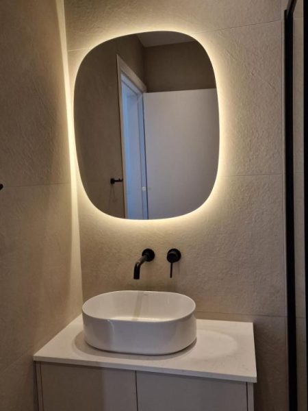 Baño moderno con lavabo de sobre encimera y espejo retroiluminado LED en Hotel Hypnos Park View