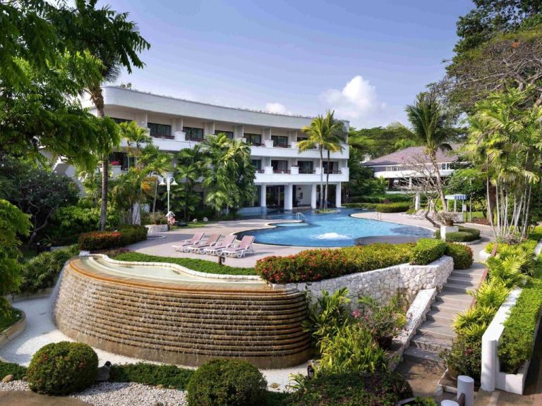 Piscina exterior con cascada y jardines tropicales del Novotel Rayong Rim Pae Resort en Tailandia
