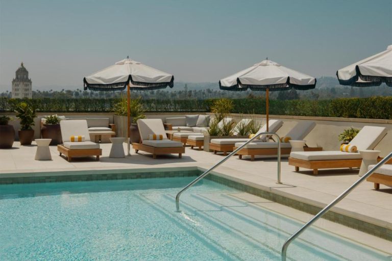 Piscina exterior con tumbonas y sombrillas en la terraza del hotel L'Ermitage Beverly Hills