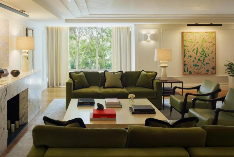 Elegante salón con sofás de terciopelo verde y chimenea de mármol en L'Ermitage Beverly Hills