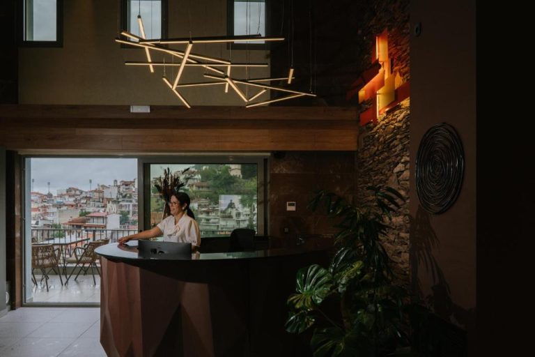 Recepción moderna del Trofonios Boutique Hotel con iluminación artística y vistas panorámicas a la ciudad