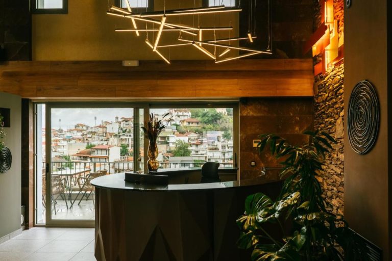Recepción moderna con iluminación artística y vistas panorámicas a la ciudad en Trofonios Boutique Hotel