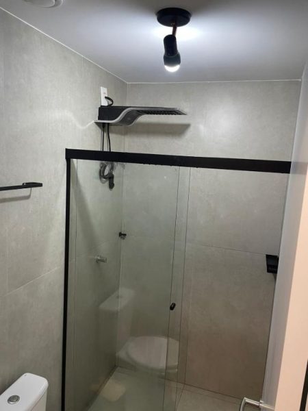 Baño moderno con ducha de cristal y cabezal de lluvia en Luxuoso Flat Salvador Corredor da Vitoria