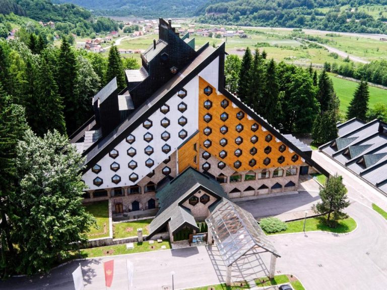 Vista aérea de la fachada exterior del Bianca Resort & Spa rodeado de bosque y montañas