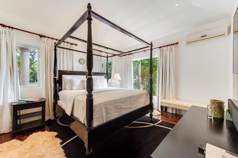 Habitación de lujo con cama de dosel de cuatro postes en The Palms Resort, suelo de madera y aire acondicionado