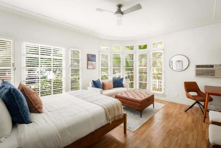 Habitación doble luminosa con ventanales y suelo de madera en Beverly Grove Hotel Los Ángeles