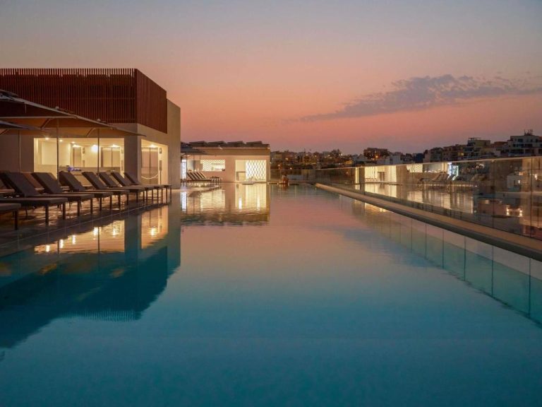Piscina infinita en la azotea del Novotel Malta Sliema con vistas a la ciudad al atardecer