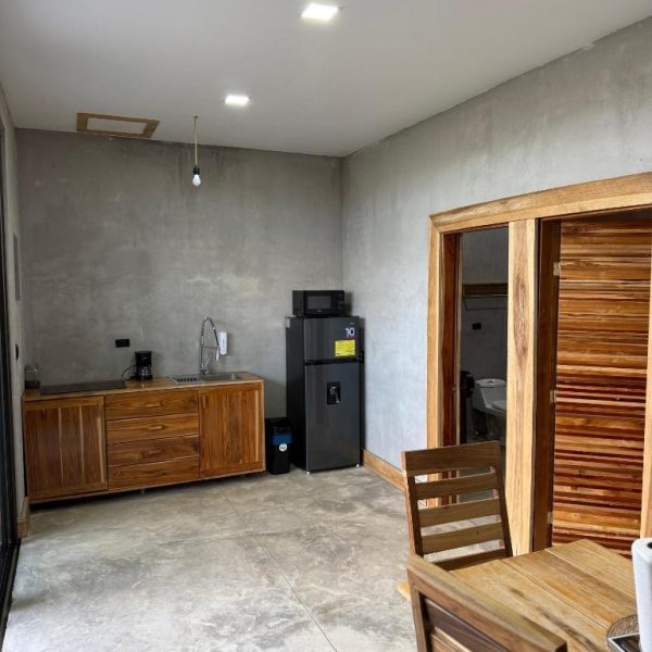 Cocina equipada con nevera, microondas y muebles de madera en Destino Hotel Hot Springs, Bagaces, Guanacaste