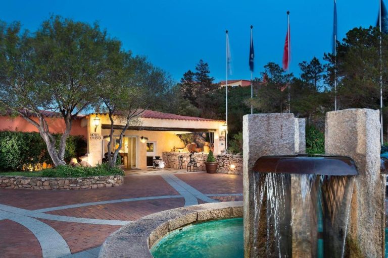 Entrada principal con fuente decorativa iluminada del Cervo Hotel Costa Smeralda Resort en Cerdeña