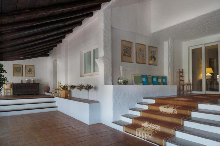 Hall de entrada con escaleras y paredes blancas del Cervo Hotel Costa Smeralda Resort en Cerdeña