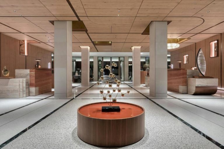 Lujoso lobby del The Landmark Nicosia con escultura dorada y diseño en madera y mármol