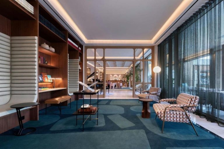 Elegante biblioteca y zona lounge del The Landmark Nicosia Autograph Collection con sillones y estanterías