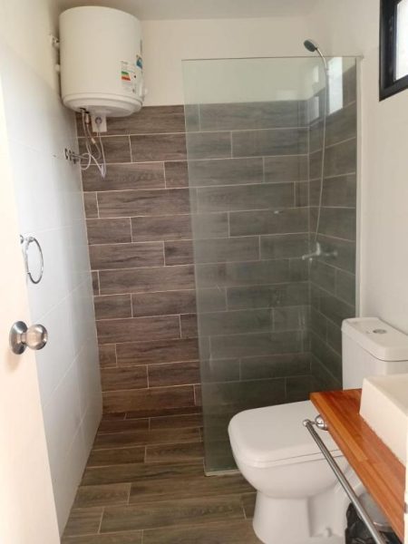 Baño moderno con ducha de cristal y calentador de agua en PLC Hotel Centenario