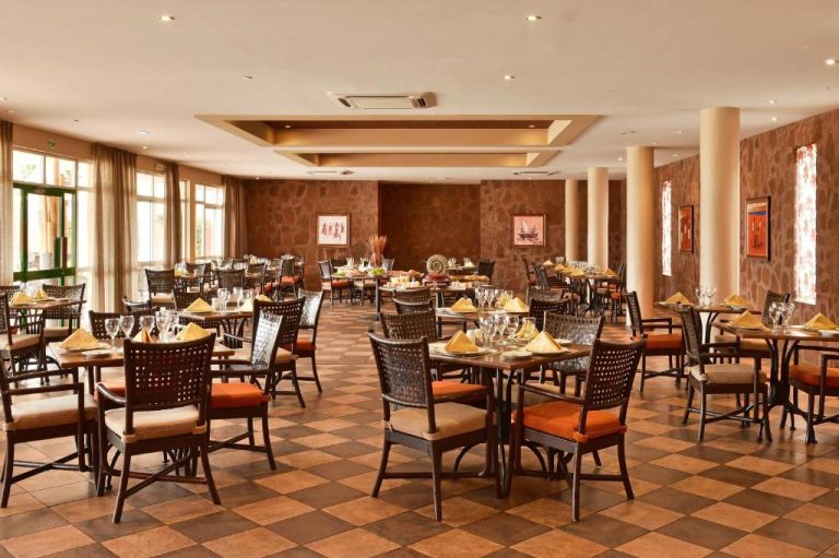 Elegante restaurante interior del Pestana Trópico con mesas preparadas y decoración en tonos cálidos