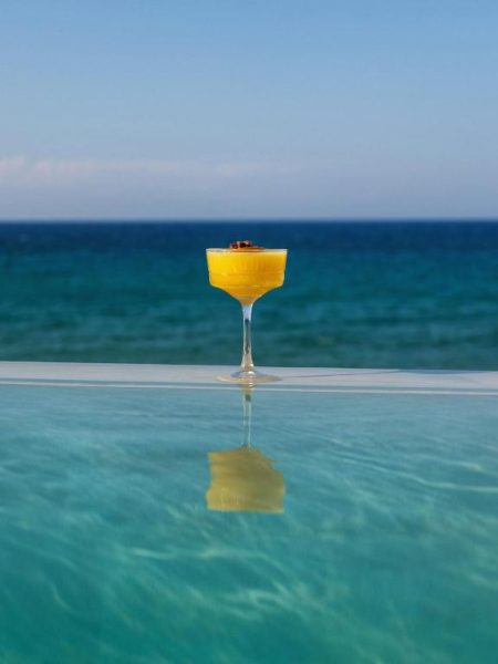 Cóctel tropical en la piscina infinita con vistas al mar turquesa del Tsamis Zante Suites