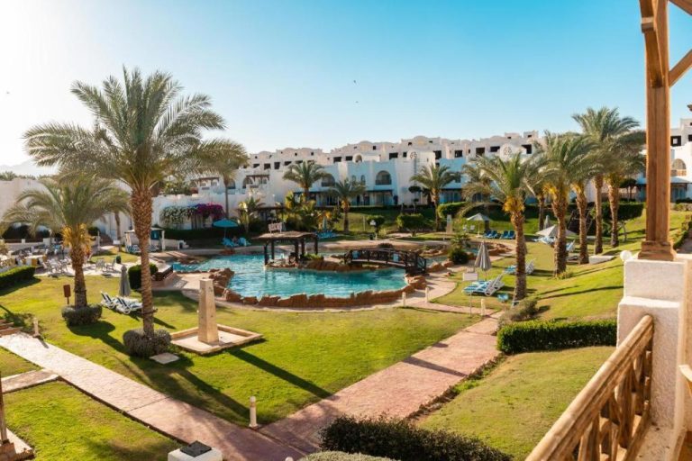 Piscina exterior rodeada de palmeras y jardines tropicales del Jaz Sharm Dream Vacation Club en Sharm el-Sheikh