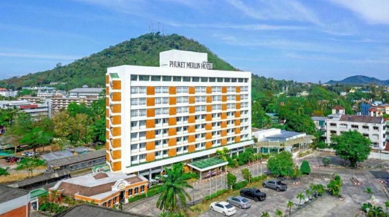 Vista aérea de la fachada exterior del Phuket Merlin Hotel con montaña verde al fondo