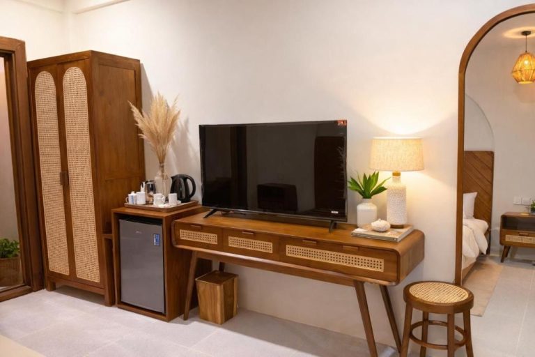 Habitación con escritorio de madera, televisor y armario de ratán en Palma De Maldives