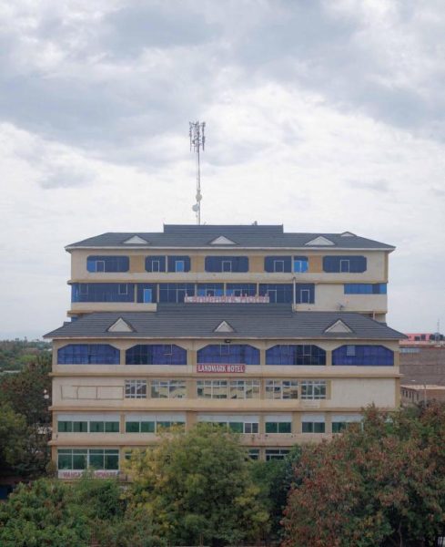Vista exterior de la fachada del Isiolo Landmark Hotel con varios pisos y ventanas azules