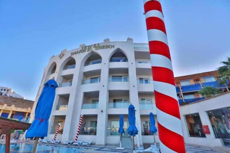 Fachada exterior con piscina y sombrillas azules del Jewel Sharm El Sheikh Hotel en Egipto