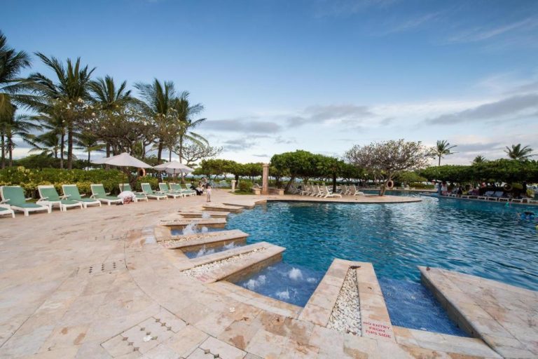 Piscina exterior con tumbonas y palmeras tropicales del Grand Hyatt Bali en Indonesia