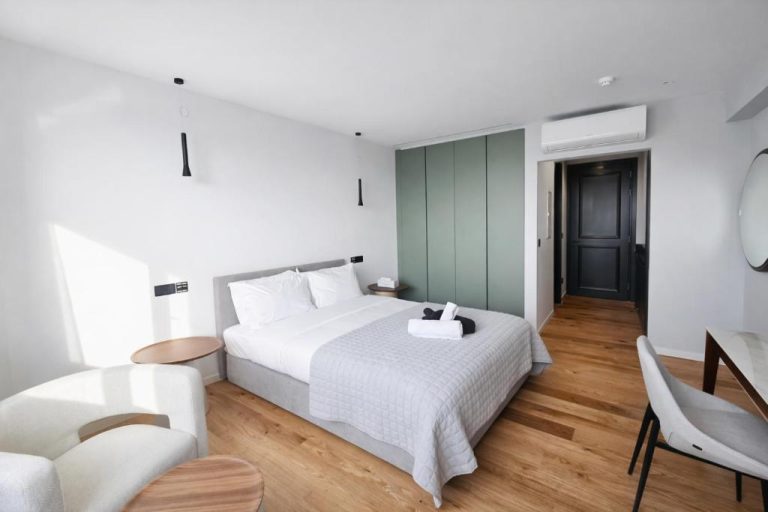 Habitación doble moderna con suelo de madera y armario verde en Sky Suites Nicosia