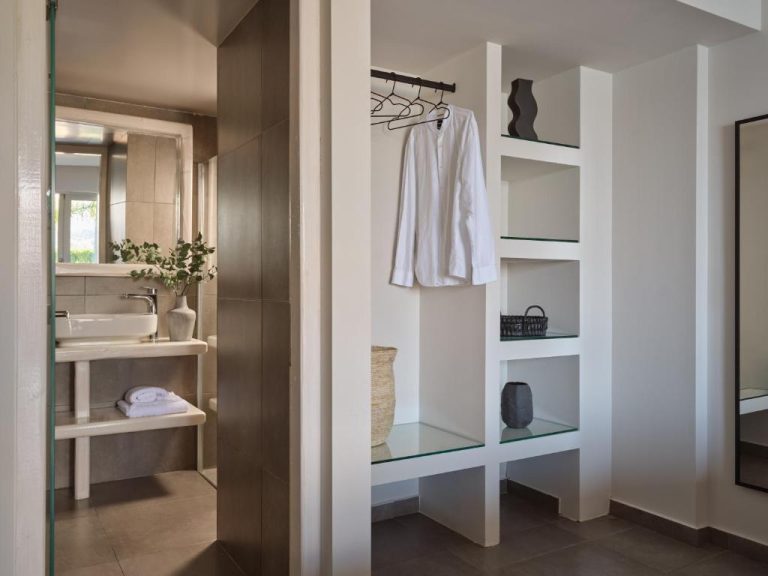 Vestidor abierto con armario y estanterías junto al baño moderno en Ionian Hill Hotel