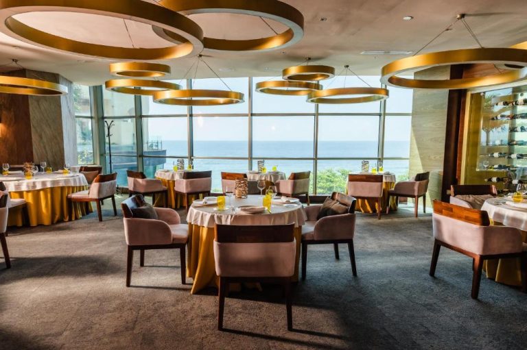 Restaurante elegante con vistas al mar del Catalonia Santo Domingo, decorado con lámparas doradas