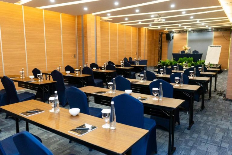 Sala de conferencias con mesas y sillas azules del Azana Style Hotel Tulungagung