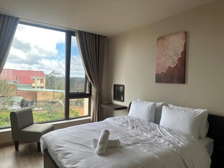 Habitación doble con cama king y ventanal panorámico con vistas al exterior en Le VyN Mang Den