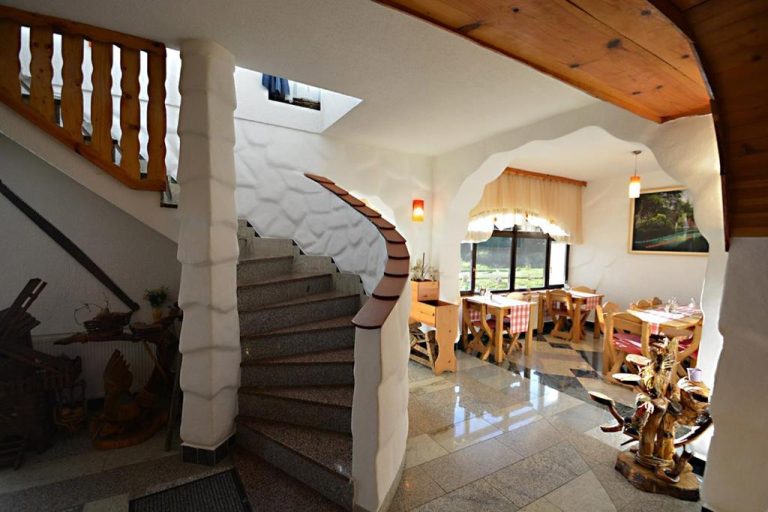 Recepción con escalera de piedra y comedor rústico de madera en Sobe Vrata Plitvica