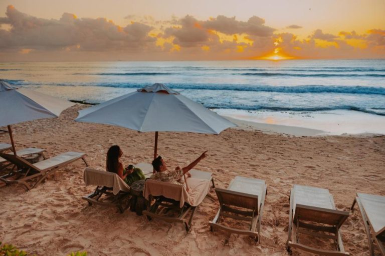 Pareja disfrutando del atardecer en la playa del Petit Lafitte Beach Front Hotel & Bungalows