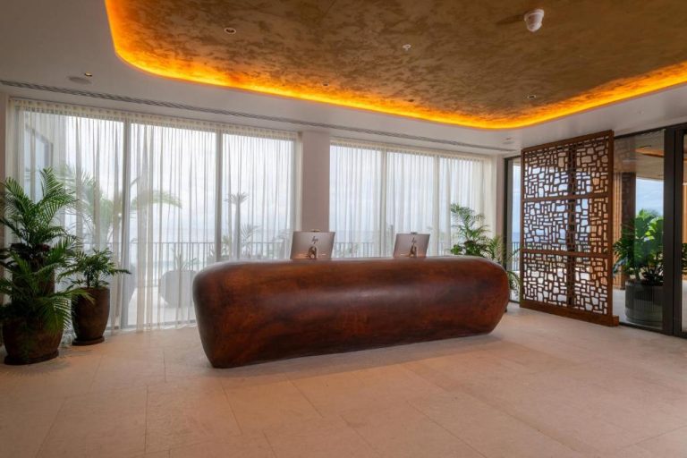 Recepción de diseño moderno con mostrador orgánico en el Hotel Indigo Bridgetown Barbados by IHG