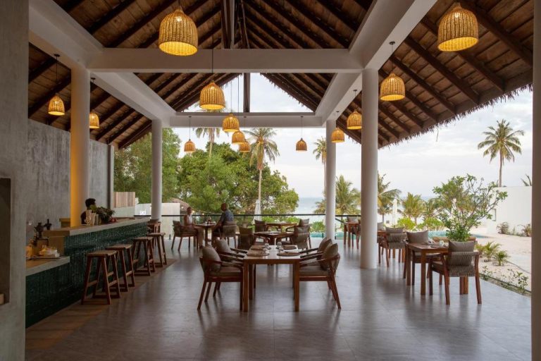 Restaurante al aire libre con vistas a la playa y palmeras en Le Baoli Koh Rong