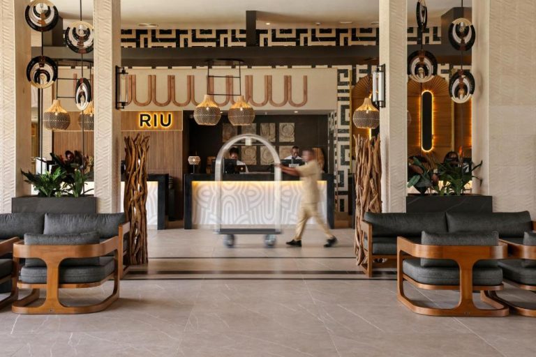Recepción y lobby del Riu Palace Swahili Adults Only con decoración africana y botones con carrito
