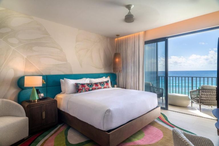 Habitación king con cabecero turquesa y balcón con vista al mar en Hotel Indigo Bridgetown Barbados