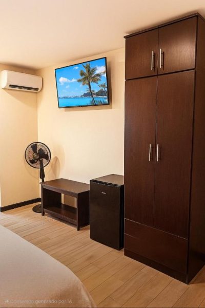 Habitación con armario de madera, televisión, aire acondicionado y minibar en Hotel Boutique 4 Estancias