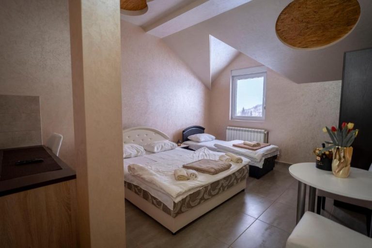 Habitación twin abuhardillada con dos camas y toallas en el Hotel Sjever