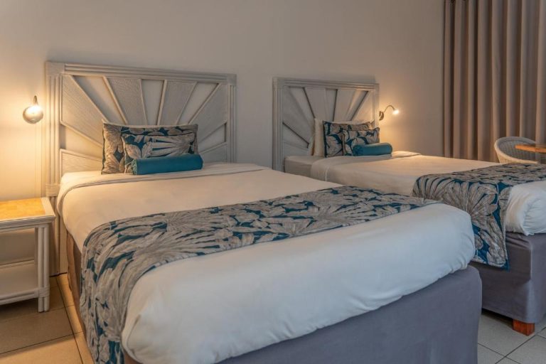 Habitación twin con dos camas individuales y decoración tropical azul en Karibea La Valmenière Hôtel