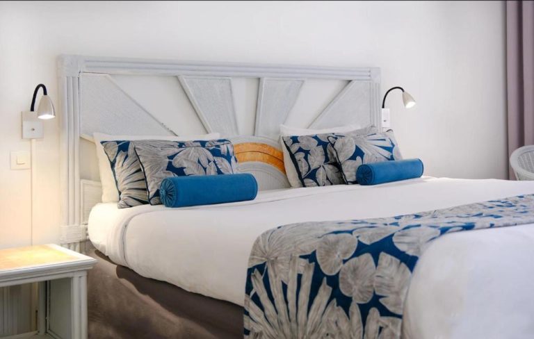 Habitación doble con cama king size y decoración en azul y blanco en Karibea La Valmenière Hôtel