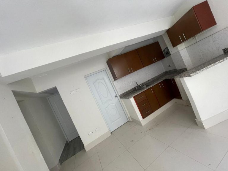 Cocina moderna con gabinetes de madera y encimera de granito en apartamento Bohio RD