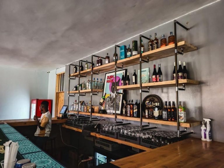 Bar con estanterías de madera y amplia selección de licores en el Piye Boutique Hotel