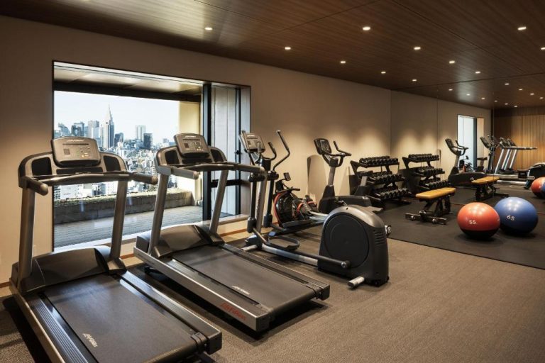 Gimnasio moderno con cintas de correr y vistas panorámicas a Tokio en The Aoyama Grand Hotel