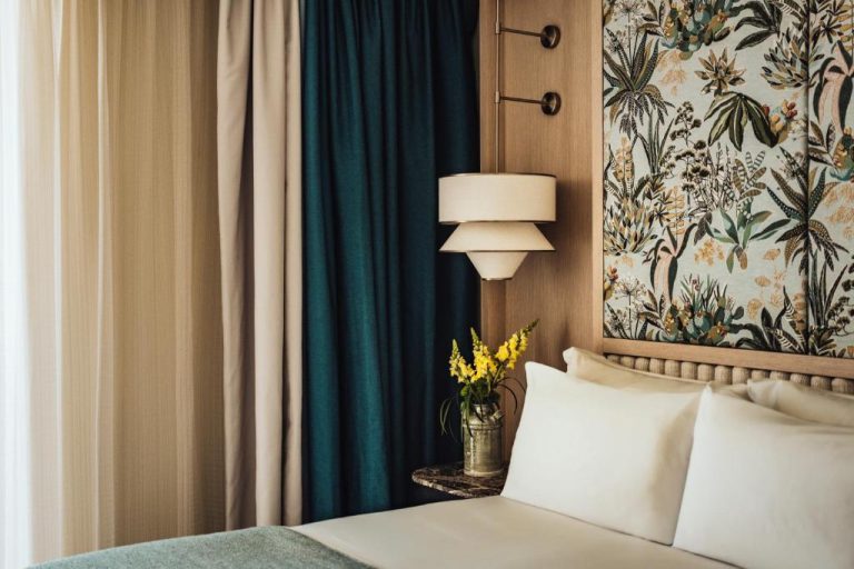 Habitación elegante con cabecero botánico y cortinas verdes en The Phoenicia Malta Leading Hotels