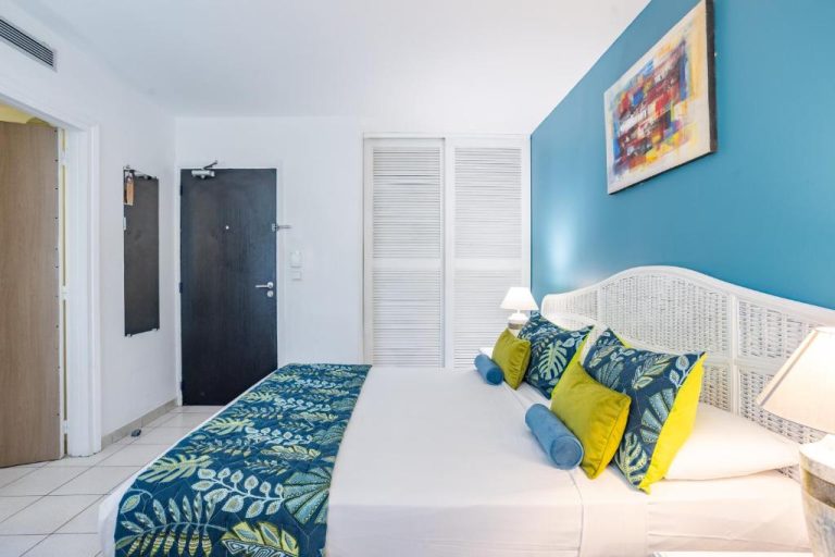 Habitación doble con cama grande y decoración tropical en tonos azules del Karibea Squash Hôtel